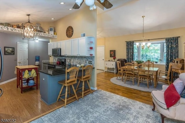 130 Lake Iliff Rd, Andover Twp, NJ 07860 - kitchen with a chandelier, electric range oven, dark countertops, stainless steel microwave, and high vaulted ceiling