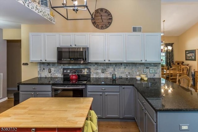 130 Lake Iliff Rd, Andover Twp, NJ 07860 - kitchen with stainless steel microwave, a chandelier, range with electric stovetop, decorative backsplash, and vaulted ceiling