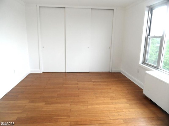 276 Prospect St, East Orange City, NJ 07017 - unfurnished bedroom with radiator heating unit, light wood-style floors, a closet, and baseboards
