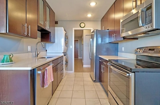 2 Claridge Dr Unit 7Ke, Verona Twp, NJ 07044 - kitchen with stainless steel appliances, estacked washer and dryer, a sink, light tile patterned floors, and light countertops