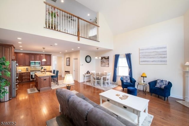 42 Bluffs Ct, Hamburg Boro, NJ 07419 - living room featuring wood finished floors, recessed lighting, a towering ceiling, and baseboards