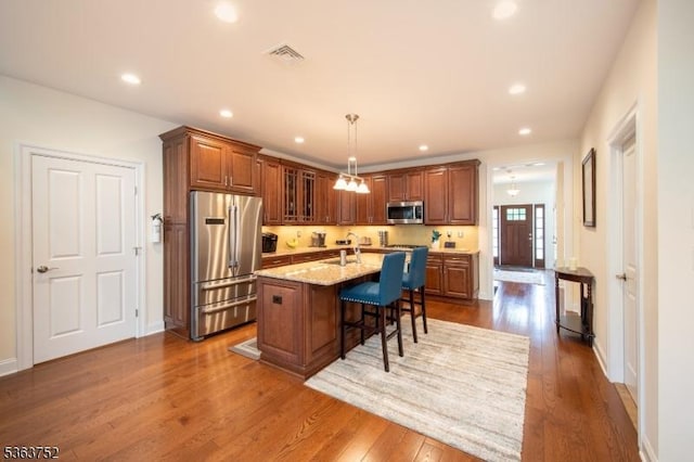 42 Bluffs Ct, Hamburg Boro, NJ 07419 - kitchen with stainless steel appliances, a breakfast bar, brown cabinets, dark wood-style flooring, and recessed lighting