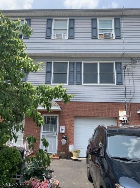 145 N 1st St Unit 2, Paterson City, NJ 07522 - townhome / multi-family property with a garage, brick siding, and cooling unit