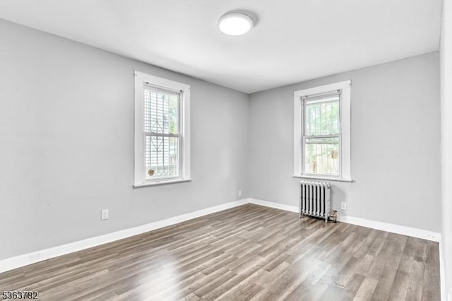 410-412 Kerrigan Blvd, Newark City, NJ 07106 - empty room with radiator heating unit, healthy amount of natural light, wood finished floors, and baseboards