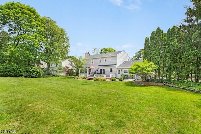 28 Douglas Dr, Washington Twp, NJ 07853 - rear view of house with a chimney, a wooden deck, and a lawn