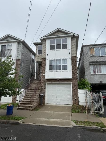48 N 5th St, Newark City, NJ 07107 - view of front facade with a garage, stairs, and concrete driveway