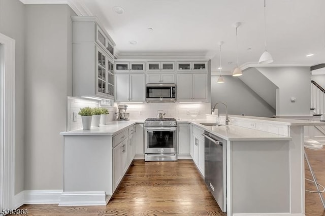 10 Central Ave Unit C, Caldwell Boro Twp, NJ 07006 - kitchen featuring appliances with stainless steel finishes, a peninsula, decorative backsplash, glass insert cabinets, and ornamental molding