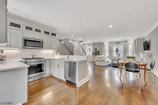 10 Central Ave Unit C, Caldwell Boro Twp, NJ 07006 - kitchen featuring appliances with stainless steel finishes, ornamental molding, a peninsula, open floor plan, and light countertops