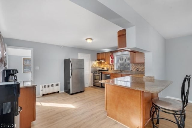 136 Willow St, Bloomfield Twp, NJ 07003 - kitchen featuring appliances with stainless steel finishes, radiator heating unit, a peninsula, light wood-style floors, and backsplash