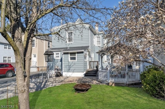 136 Willow St, Bloomfield Twp, NJ 07003 - view of front of house with a fire pit, a front lawn, and a wooden deck
