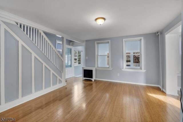 136 Willow St, Bloomfield Twp, NJ 07003 - unfurnished living room featuring stairs, wood-type flooring, radiator, and baseboards