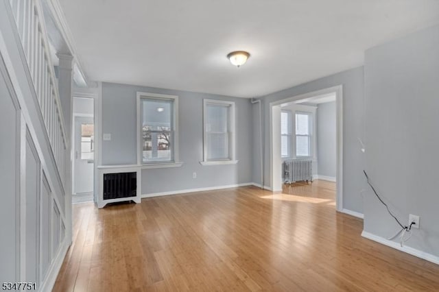 136 Willow St, Bloomfield Twp, NJ 07003 - unfurnished living room with radiator heating unit, light wood-style flooring, baseboards, and stairs