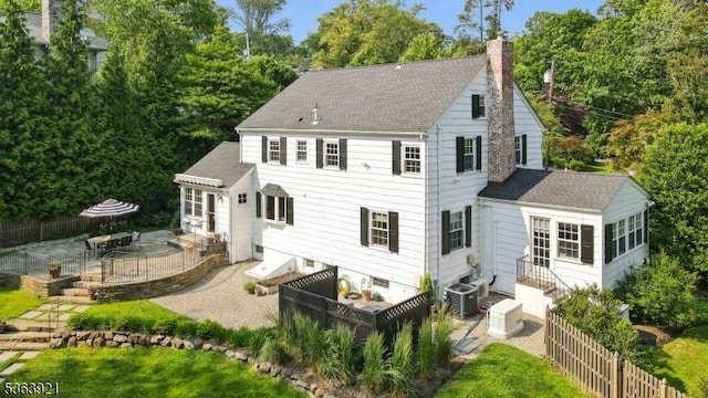 75 Farley Rd, Millburn Twp, NJ 07078 - back of house featuring a chimney, a shingled roof, a patio, entry steps, and view of wooded area