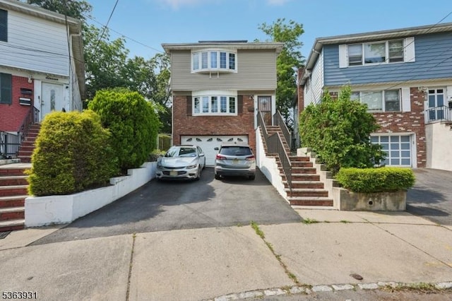 9 Lee Ct, Maplewood Twp, NJ 07040 - view of property with stairs, driveway, an attached garage, and brick siding