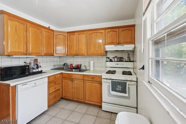 9 Lee Ct, Maplewood Twp, NJ 07040 - kitchen with white appliances, under cabinet range hood, light countertops, and decorative backsplash