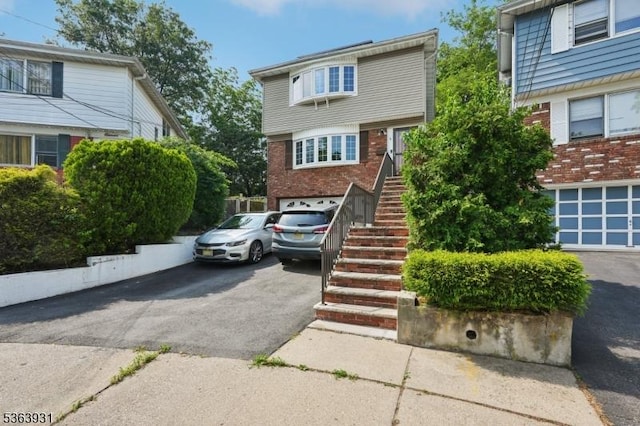 9 Lee Ct, Maplewood Twp, NJ 07040 - view of front of house featuring asphalt driveway, a garage, stairs, and brick siding
