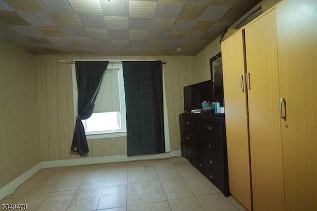 63 Grove St, Bloomfield Twp, NJ 07003 - unfurnished bedroom with wooden walls and light tile patterned floors