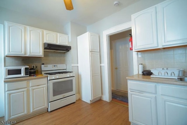 63 Grove St, Bloomfield Twp, NJ 07003 - kitchen featuring white appliances, under cabinet range hood, tasteful backsplash, and white cabinetry