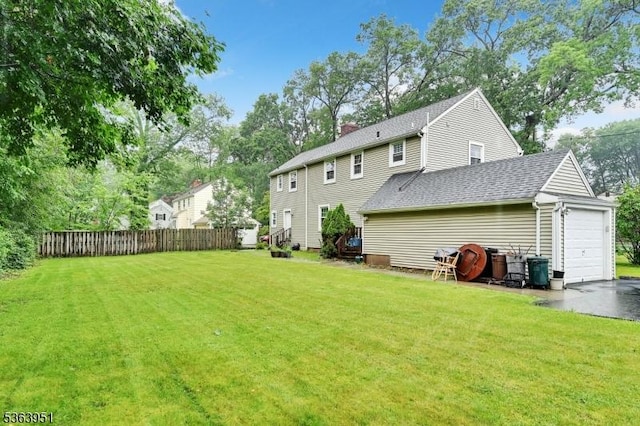 329 Hillside Ave, Livingston Twp, NJ 07039 - back of property featuring a shingled roof, a garage, a chimney, and asphalt driveway