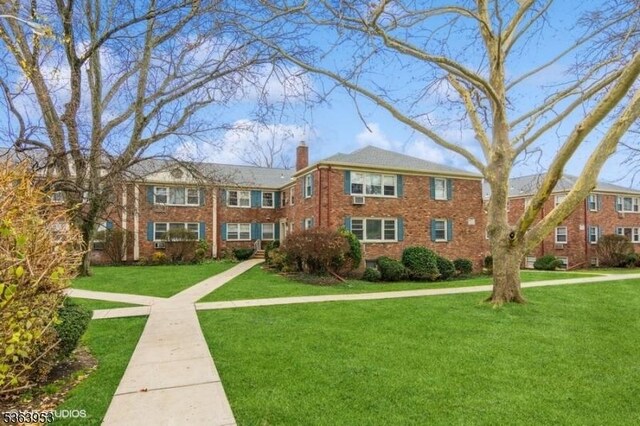 24 Hutton Ave Unit 46, West Orange Twp, NJ 07052 - view of front of house with a chimney, a front yard, and brick siding
