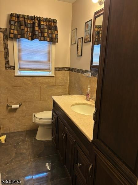 85 Stonehenge Ter, Clark Twp, NJ 07066 - bathroom with tile walls, vanity, tile patterned floors, and wainscoting