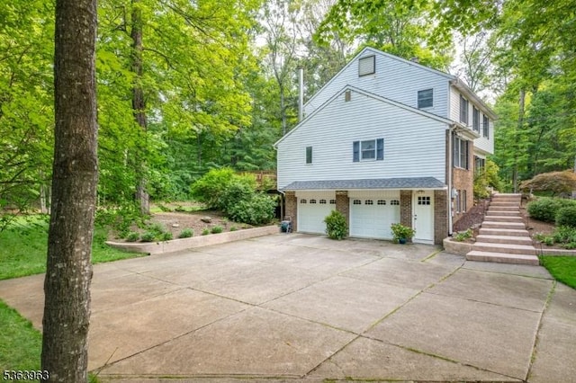 46 Deerfield Dr, Hardyston Twp, NJ 07416 - view of side of home featuring a garage, brick siding, driveway, and stairway