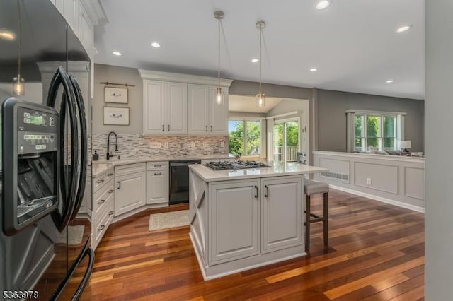 1611 Adams Dr, Greenwich Twp, NJ 08886 - kitchen featuring appliances with stainless steel finishes, a kitchen island, white cabinetry, tasteful backsplash, and dark wood finished floors