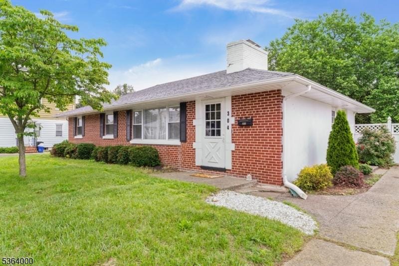 304 N 7th Ave, Manville Boro, NJ 08835 - ranch-style house featuring a chimney, brick siding, and a front lawn