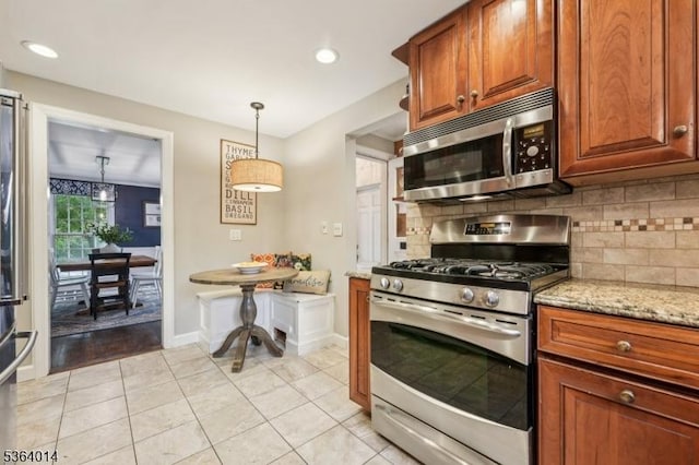 64 Mckinley Ave, West Caldwell Twp, NJ 07006 - kitchen with stainless steel appliances, backsplash, light stone counters, light tile patterned floors, and pendant lighting