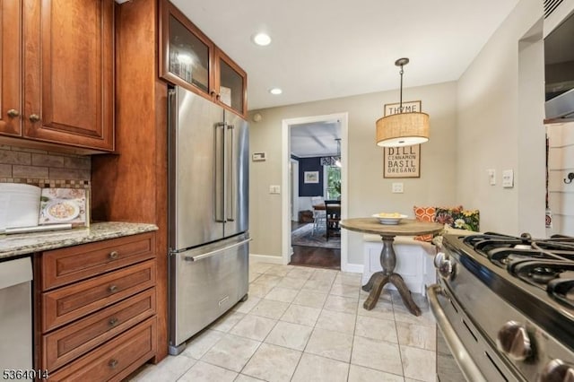 64 Mckinley Ave, West Caldwell Twp, NJ 07006 - kitchen featuring stainless steel appliances, decorative backsplash, glass insert cabinets, light stone countertops, and decorative light fixtures