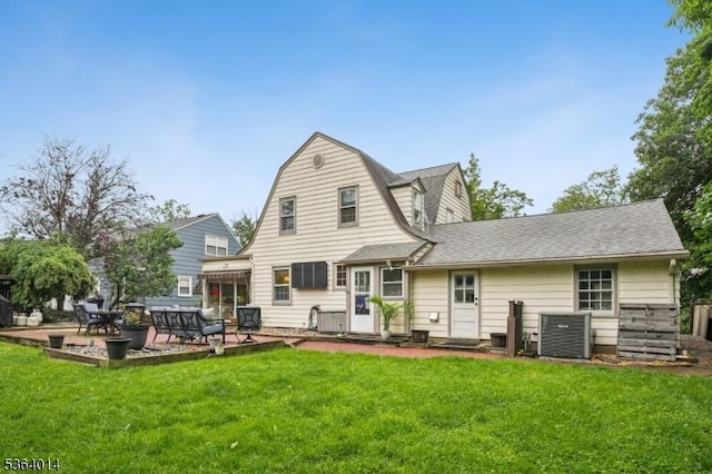 64 Mckinley Ave, West Caldwell Twp, NJ 07006 - rear view of property featuring a lawn, a patio, a shingled roof, and a gambrel roof