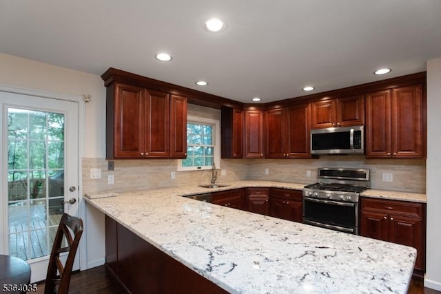 13 Deer Path Cir, Green Brook Twp, NJ 08812 - kitchen with appliances with stainless steel finishes, recessed lighting, backsplash, light stone counters, and a peninsula
