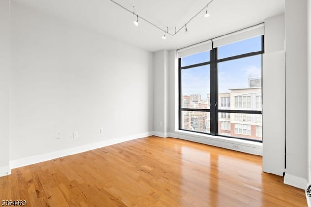 1025 Maxwell Ln Unit 1209, Hoboken City, NJ 07030 - unfurnished room featuring rail lighting, wood finished floors, and a view of city