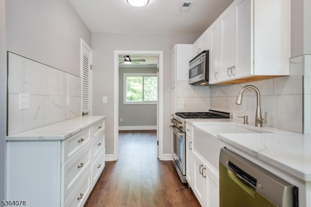 2 Falkenstein Dr Unit 10, Vernon Twp, NJ 07462 - kitchen with appliances with stainless steel finishes, ceiling fan, tasteful backsplash, white cabinets, and dark wood finished floors