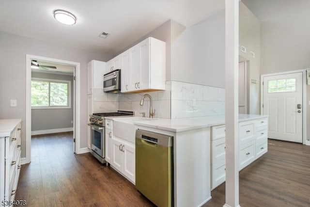 2 Falkenstein Dr Unit 10, Vernon Twp, NJ 07462 - kitchen featuring appliances with stainless steel finishes, dark wood-type flooring, tasteful backsplash, white cabinetry, and ceiling fan