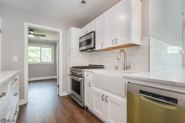 2 Falkenstein Dr Unit 10, Vernon Twp, NJ 07462 - kitchen with appliances with stainless steel finishes, dark wood-type flooring, backsplash, white cabinetry, and ceiling fan