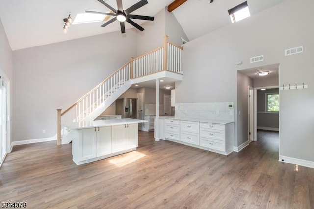 2 Falkenstein Dr Unit 10, Vernon Twp, NJ 07462 - unfurnished living room with high vaulted ceiling, a ceiling fan, light wood-type flooring, stairs, and beamed ceiling