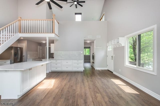 2 Falkenstein Dr Unit 10, Vernon Twp, NJ 07462 - unfurnished living room featuring a ceiling fan, a towering ceiling, wood finished floors, and stairway