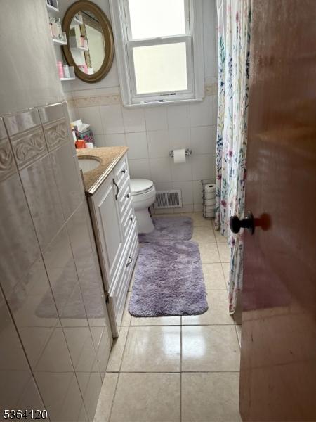 1221 Grant Ave, Plainfield City, NJ 07060 - bathroom featuring vanity, tile patterned flooring, tile walls, and curtained shower