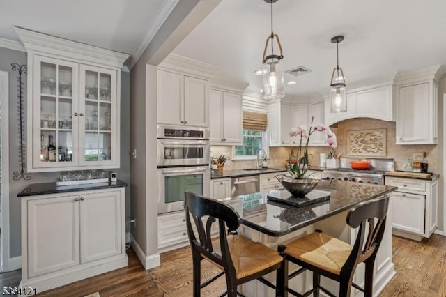 198 Pittsford Way, New Providence Boro, NJ 07974 - kitchen featuring appliances with stainless steel finishes, crown molding, dark wood finished floors, a kitchen bar, and white cabinets