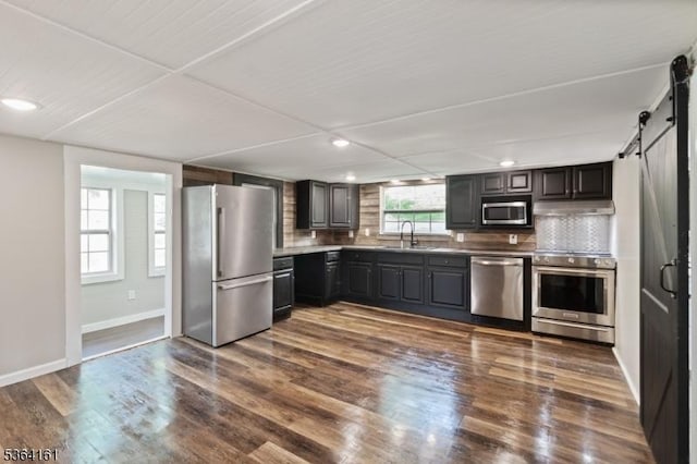 132 Axford Ave, Oxford Twp, NJ 07863 - kitchen featuring appliances with stainless steel finishes, a barn door, decorative backsplash, a sink, and recessed lighting