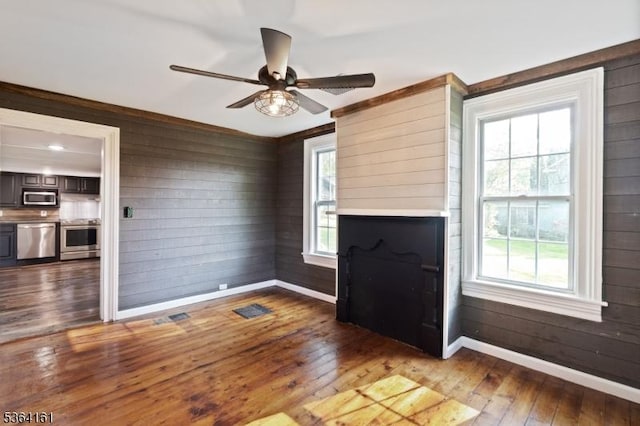 132 Axford Ave, Oxford Twp, NJ 07863 - unfurnished living room with baseboards, hardwood / wood-style floors, wood walls, and ceiling fan