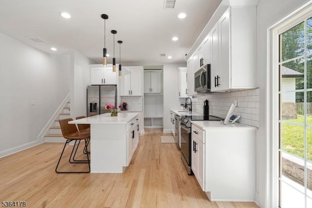 29 Tennis Rd, Jefferson Twp, NJ 07849 - kitchen with stainless steel appliances, a center island, light wood-style flooring, decorative backsplash, and recessed lighting