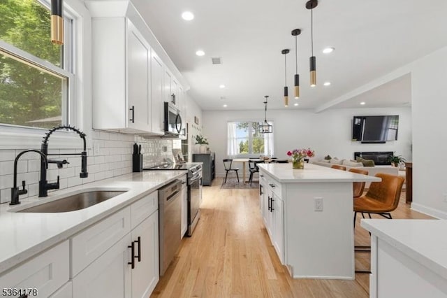 29 Tennis Rd, Jefferson Twp, NJ 07849 - kitchen with appliances with stainless steel finishes, decorative backsplash, a kitchen bar, a kitchen island, and open floor plan