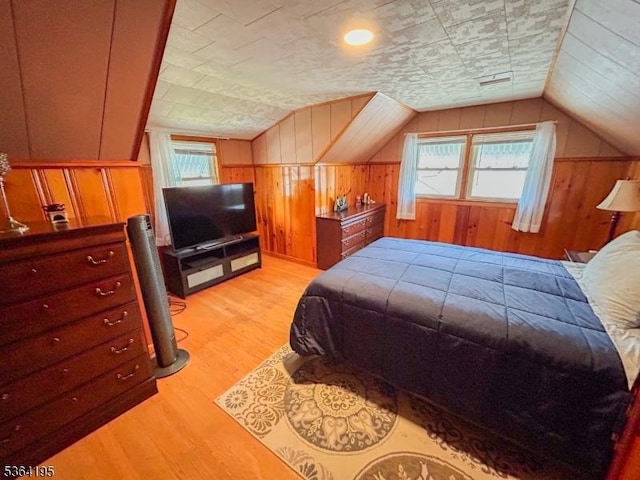 23 Bogle Ave, North Arlington Boro, NJ 07031 - bedroom featuring multiple windows, wood walls, light wood-style floors, and lofted ceiling