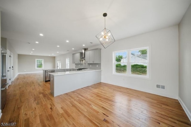 181 Randolph Ave, Mine Hill Twp, NJ 07803 - kitchen featuring a peninsula, wall chimney range hood, light countertops, open floor plan, and light wood-type flooring