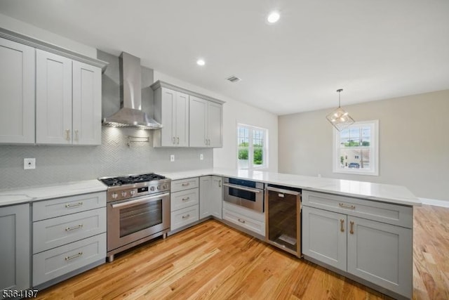 181 Randolph Ave, Mine Hill Twp, NJ 07803 - kitchen with appliances with stainless steel finishes, wall chimney exhaust hood, gray cabinetry, a peninsula, and beverage cooler