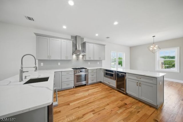181 Randolph Ave, Mine Hill Twp, NJ 07803 - kitchen featuring gray cabinetry, a peninsula, appliances with stainless steel finishes, wall chimney exhaust hood, and recessed lighting