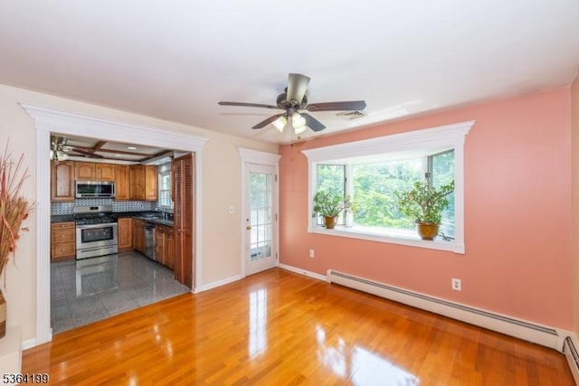 11 Putters Rd, Roxbury Twp, NJ 07876 - kitchen featuring appliances with stainless steel finishes, a baseboard heating unit, brown cabinets, ceiling fan, and dark countertops