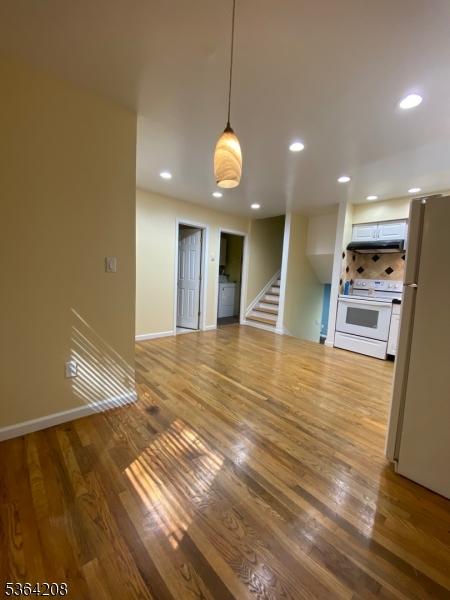 9 Village Way Unit B5, Vernon Twp, NJ 07462 - unfurnished living room featuring wood finished floors, recessed lighting, stairway, and washer / clothes dryer
